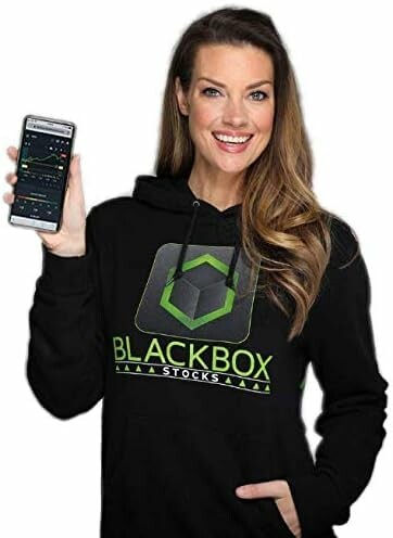 Smiling woman holding a smartphone displaying a stock app, wearing a Blackbox stocks hoodie.